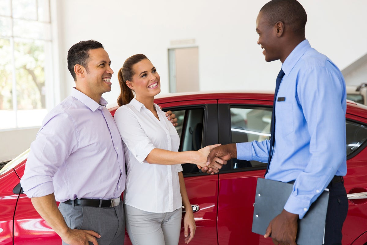 Shaking hands with the salesman after buying a car