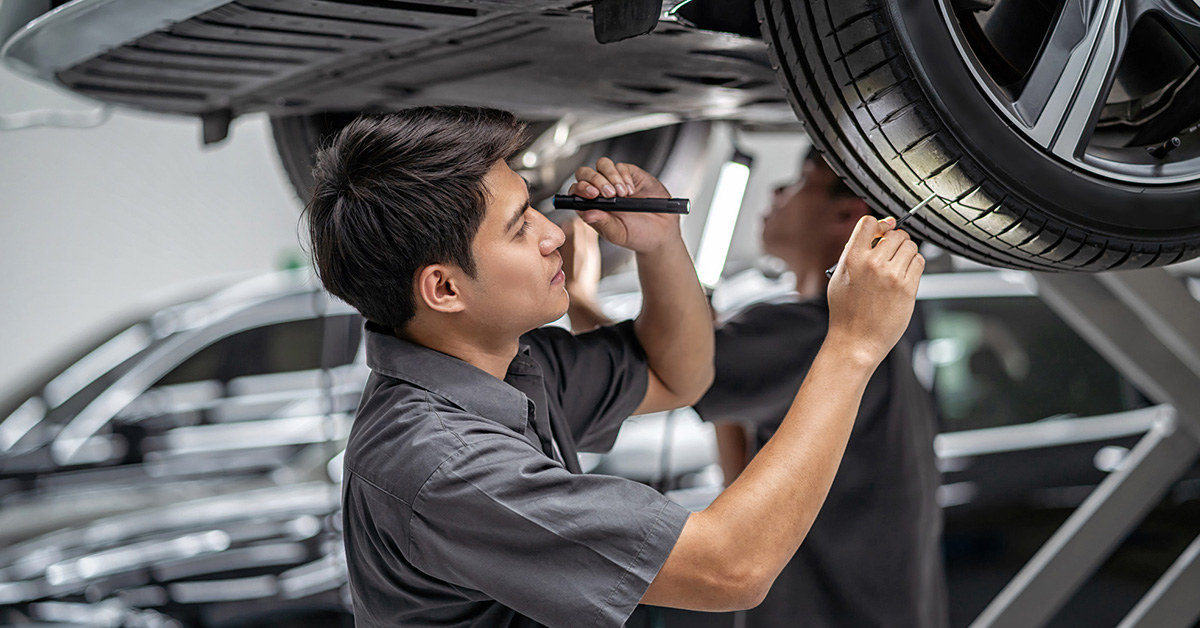 GMC service tech inspecting tires